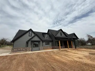 Modern farmhouse featuring brick siding and roof with shingles