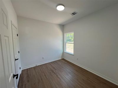 Bedroom with dark hardwood / wood-style flooring