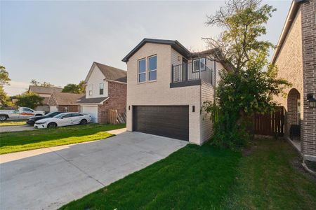 View of front of property with a balcony, a garage, and a front lawn