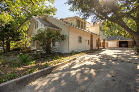 View of property exterior with a garage and an outdoor structure