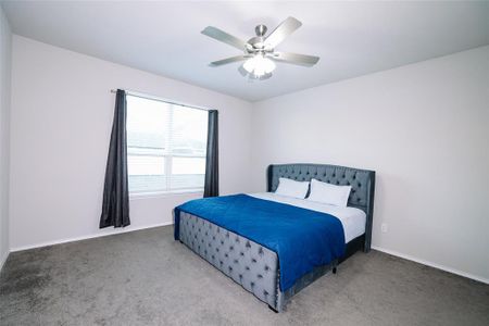 Carpeted bedroom with ceiling fan