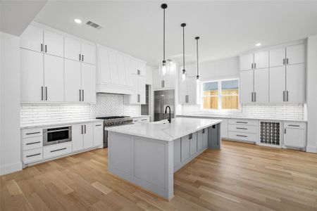 Stepping back inside, you'll be impressed by the scale and functionality of the kitchen. Equipped w/ quartz countertops, farm sink, JennAir Appliances, under cabinet lighting, recessed outlets underneath the cabinets, space for a wine fridge and soft closing on-site built custom cabinetry.