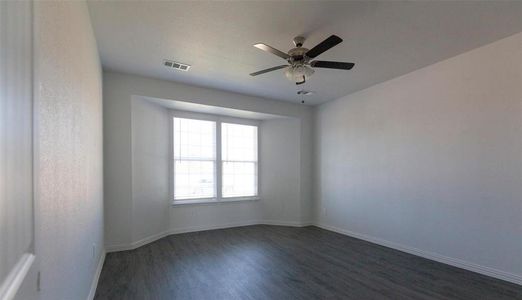 Unfurnished room featuring ceiling fan and dark wood-type flooring