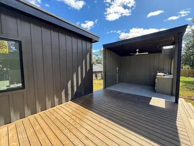 Wooden terrace featuring ceiling fan and fence