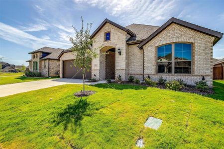 French country style house with a garage and a front lawn