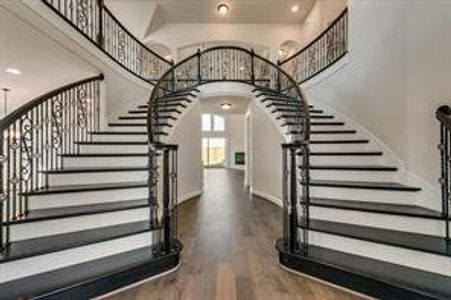 Stairs featuring hardwood / wood-style floors and a towering ceiling