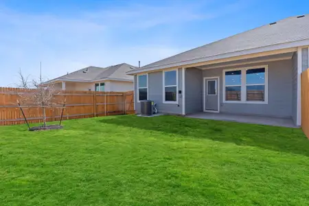 Rear view of property with central AC unit, a patio area, fence, and a yard