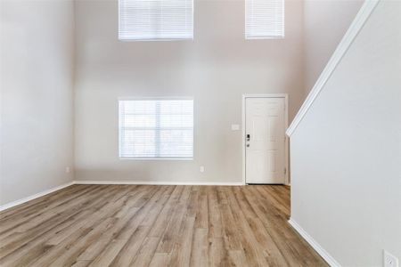 Entrance foyer featuring a towering ceiling and light hardwood / wood-style floors