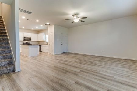 Unfurnished living room with light hardwood / wood-style flooring, sink, and ceiling fan