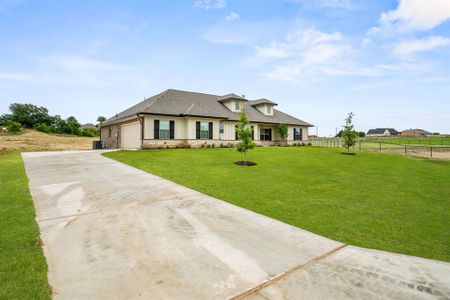 View of front facade featuring a garage and a front lawn