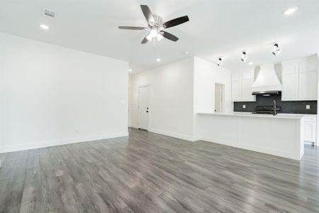 Kitchen featuring white cabinets, custom range hood, hardwood / wood-style floors, electric range, and ceiling fan