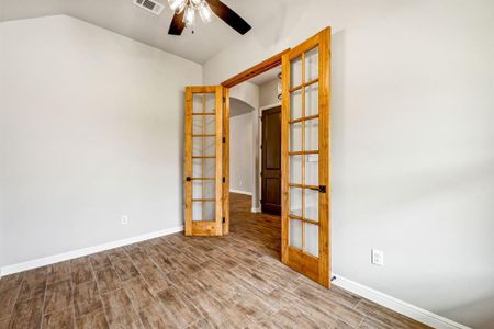 Unfurnished room with french doors, lofted ceiling, hardwood / wood-style flooring, and ceiling fan