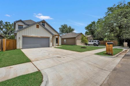 View of front of property featuring a garage and a front yard