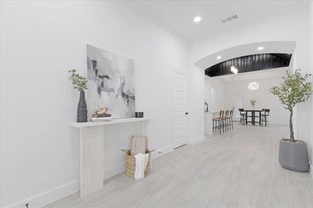 Corridor with baseboards, visible vents, and light wood-style floors