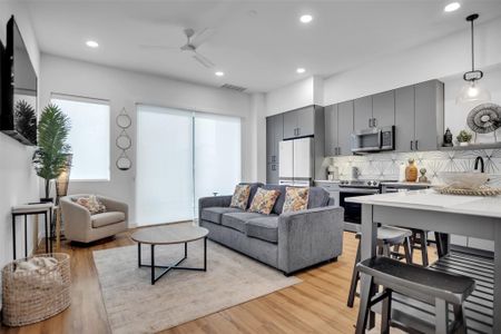 Living room featuring light wood-style floors, recessed lighting, visible vents, and a ceiling fan