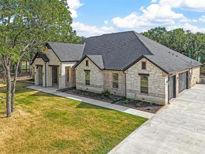 French provincial home featuring a garage and a front yard