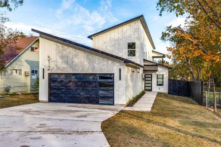 View of front facade featuring a garage and a front lawn