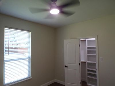 Unfurnished bedroom featuring multiple windows and ceiling fan