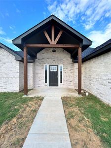 Property entrance featuring a patio and a lawn