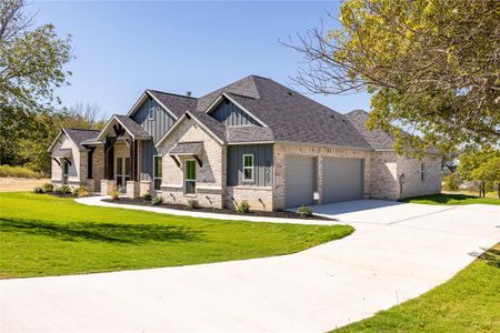 View of front facade featuring a front lawn and a garage