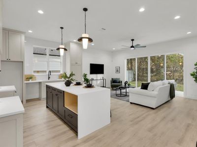 Kitchen featuring a kitchen island, ceiling fan, decorative light fixtures, light hardwood / wood-style flooring, and white cabinetry