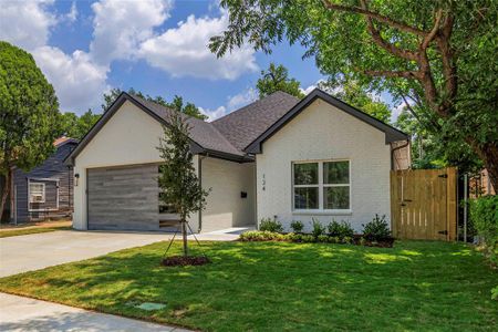 Single story home featuring a garage and a front lawn