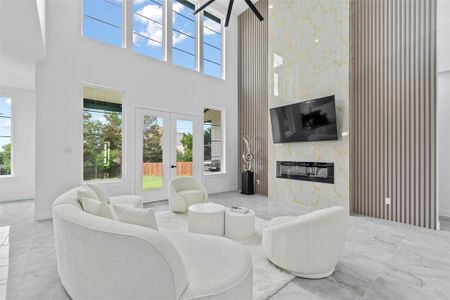 Living room featuring tile walls, a high ceiling, and a high end fireplace