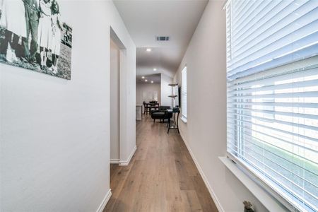 Corridor with baseboards, visible vents, wood finished floors, and recessed lighting