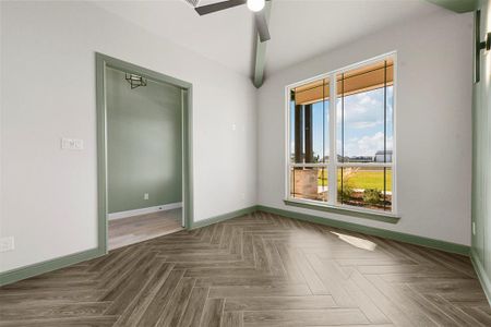 Office with dark herringbone pattern flooring and ceiling fan