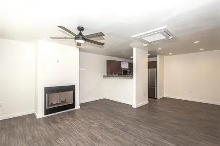 living room featuring ceiling fan,  wood-type flooring, and a textured ceiling