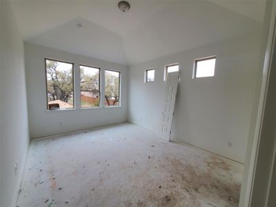 Unfurnished room featuring lofted ceiling and a wealth of natural light