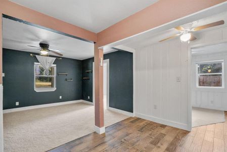 Empty room with a healthy amount of sunlight, wood-type flooring, and ceiling fan