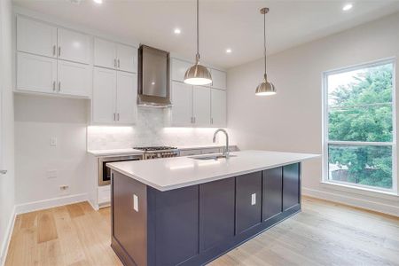 The open kitchen is bathed in natural light from large windows on both sides, creating a bright and welcoming atmosphere.