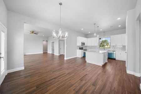 Kitchen featuring pendant lighting, dark hardwood / wood-style flooring, appliances with stainless steel finishes, and a kitchen island