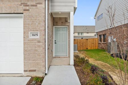 Entrance to property with a garage, a yard, and central air condition unit