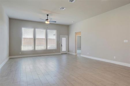 Unfurnished room with ceiling fan and light wood-type flooring