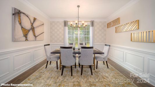 Large dining room with both wainscotting a crown molding, perfect for entertaining.