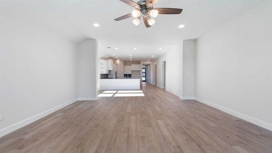 Unfurnished living room featuring ceiling fan and light hardwood / wood-style floors