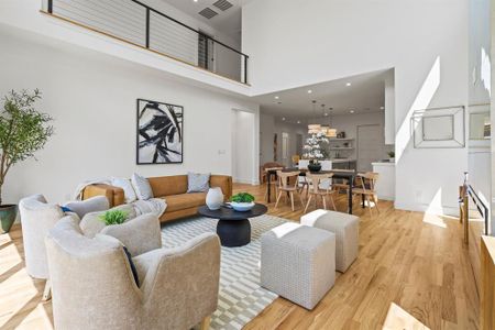 Living room featuring light hardwood / wood-style flooring and a towering ceiling