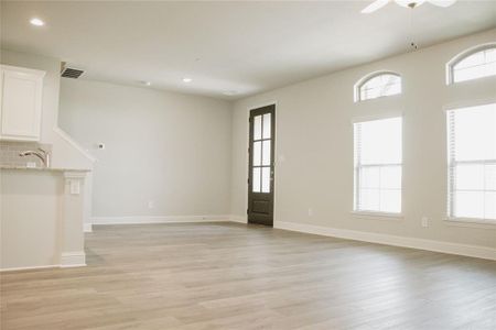 Empty room with ceiling fan, light hardwood / wood-style flooring, and sink