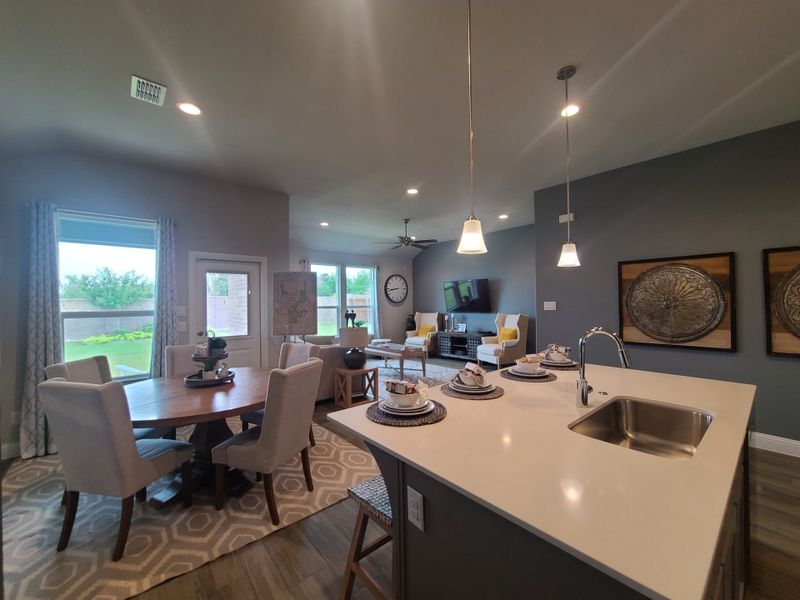 An open-concept living space featuring a sleek kitchen, cozy dining area, and inviting sitting room with modern decor. An open-concept living space featuring a sleek kitchen, cozy dining area, and inviting sitting room with modern decor.