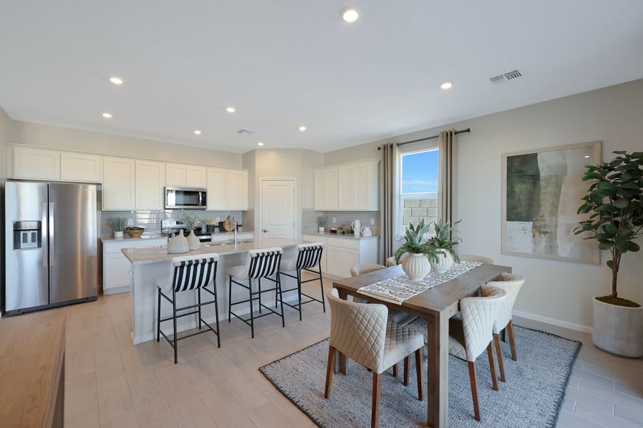 A kitchen with a dining table and chairs. A kitchen with a dining table and chairs.