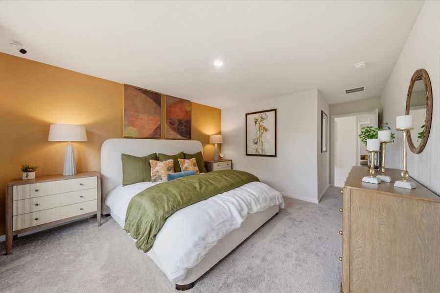 A bedroom with a bed and lamps.