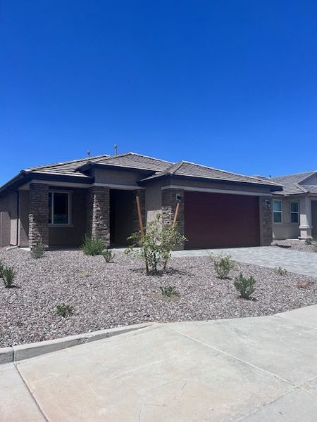A modern home with stone accents and desert landscaping in The Views at Rancho Cabrillo by Scott Communities (Peoria, AZ).