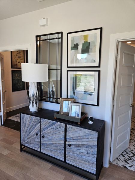 Modern entryway with an artistic sideboard, abstract art, and a decorative lamp, creating a stylish and welcoming atmosphere.