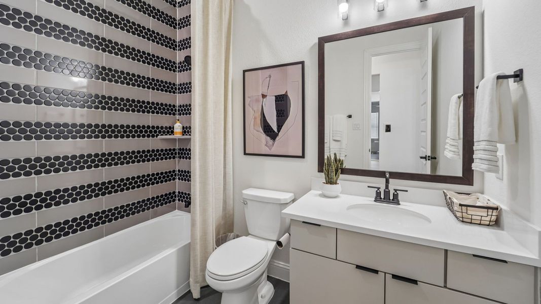 Experience opulence with striking black hexagon tiles and sleek fixtures in The Woodlands Hills.