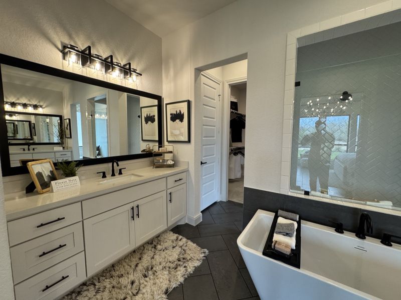A sleek bathroom with a freestanding tub, dual sinks on a long vanity, and elegant lighting for modern comfort. A sleek bathroom with a freestanding tub, dual sinks on a long vanity, and elegant lighting for modern comfort.