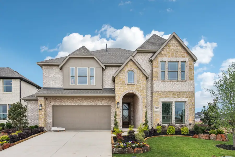 Two-story home with stone and brick exterior, two-car garage, arched entry, and landscaped front yard Two-story home with stone and brick exterior, two-car garage, arched entry, and landscaped front yard