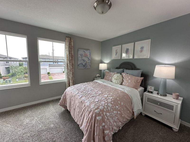 A cozy bedroom featuring soft floral bedding, pastel walls, and elegant lamps, creating a tranquil, inviting ambiance. A cozy bedroom featuring soft floral bedding, pastel walls, and elegant lamps, creating a tranquil, inviting ambiance.