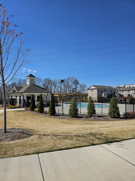 A scenic community pool area with a clubhouse and manicured lawns in Brackley Single Family by The Providence Group (Cumming, GA).